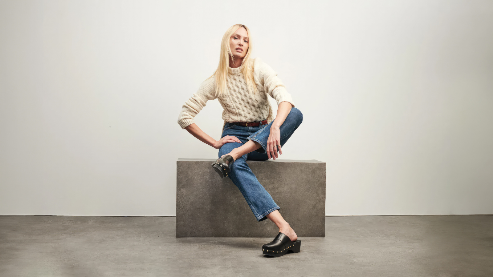 Модель Кэндис Свейнпол сидит на фоне серой стены