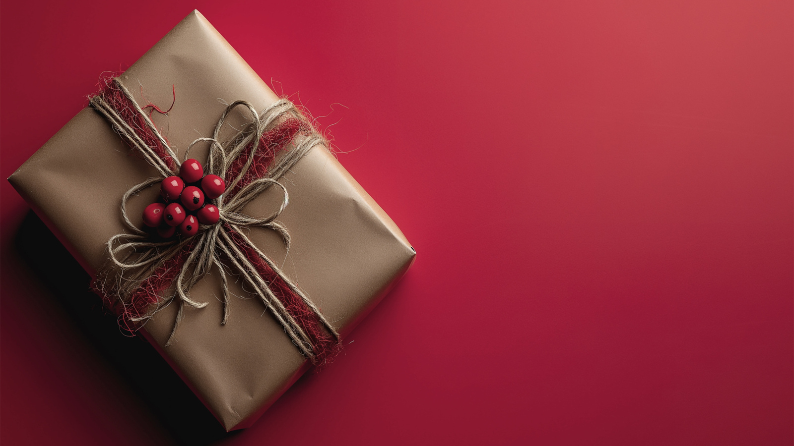 Подарок в бумаге на красном фоне