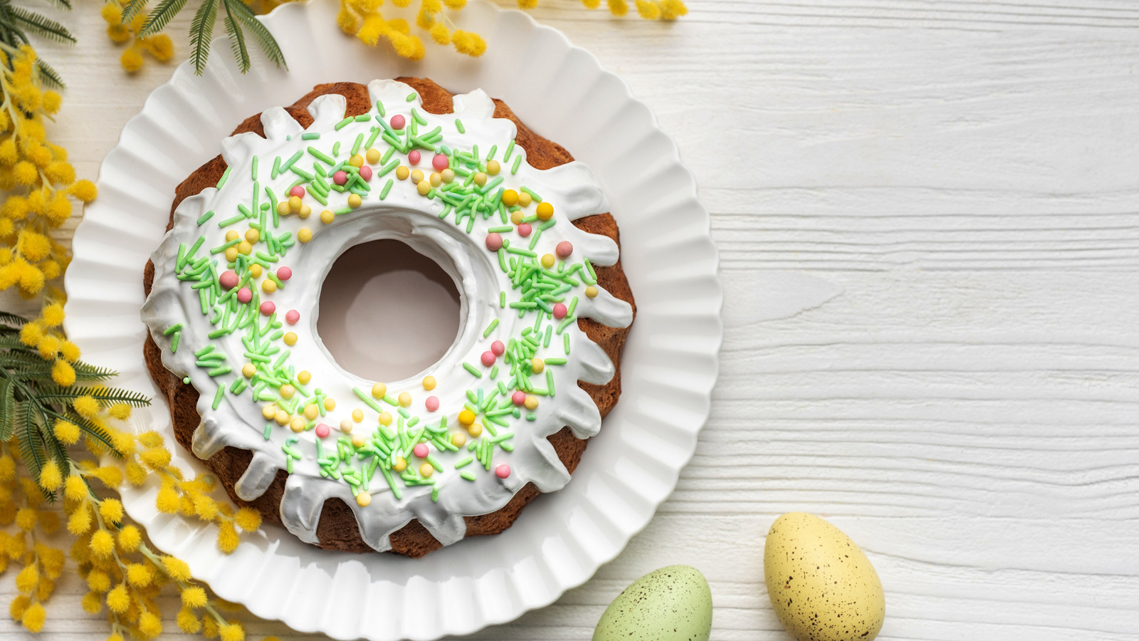 Красивый пасхальный кулич с веткой мимозы и яйцами