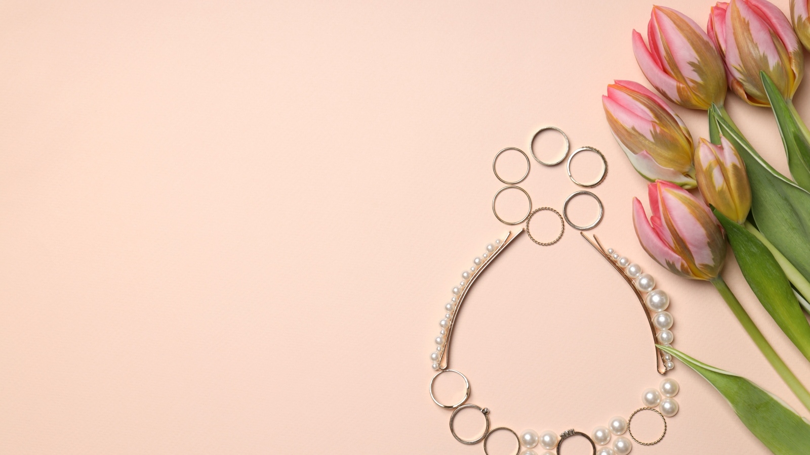 Цифра 8 из украшений на фоне с розовыми тюльпанами