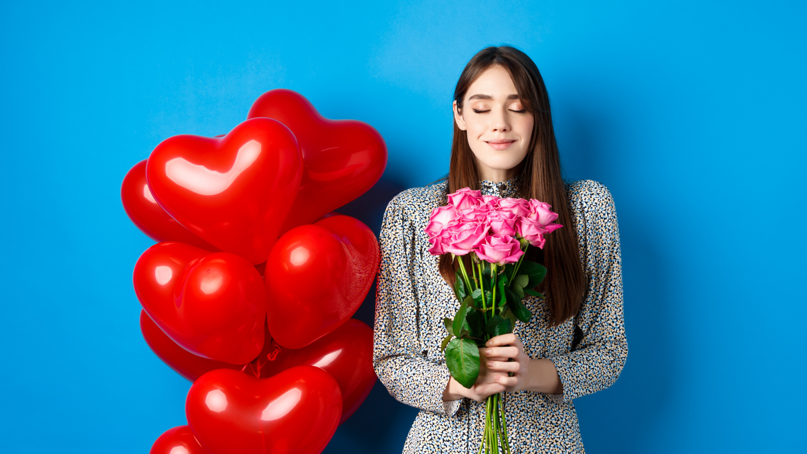 Девушка с букетом роз и воздушными шарами на день Влюбленных