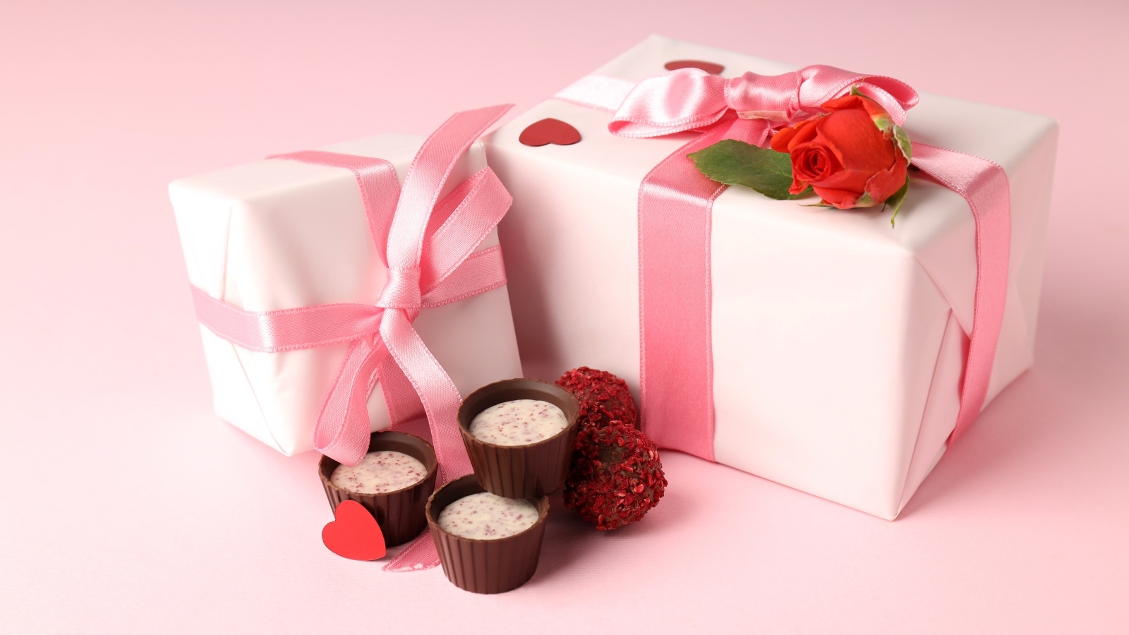 Два подарка с конфетами на розовом фоне на День Святого Валентина