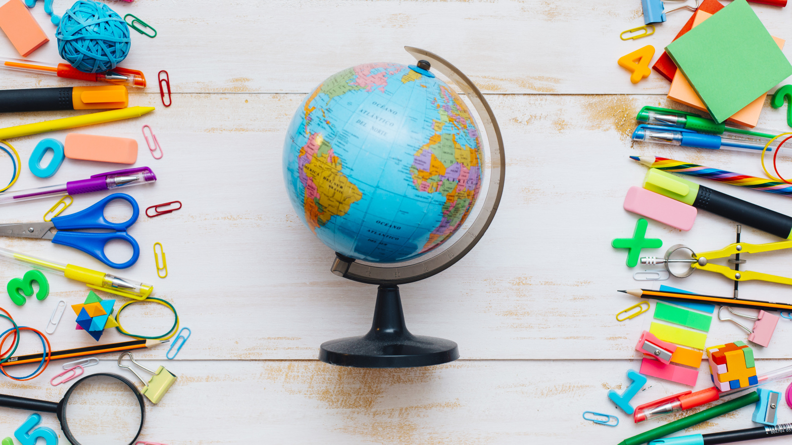 Глобус на деревянном фоне с канцелярскими предметами
