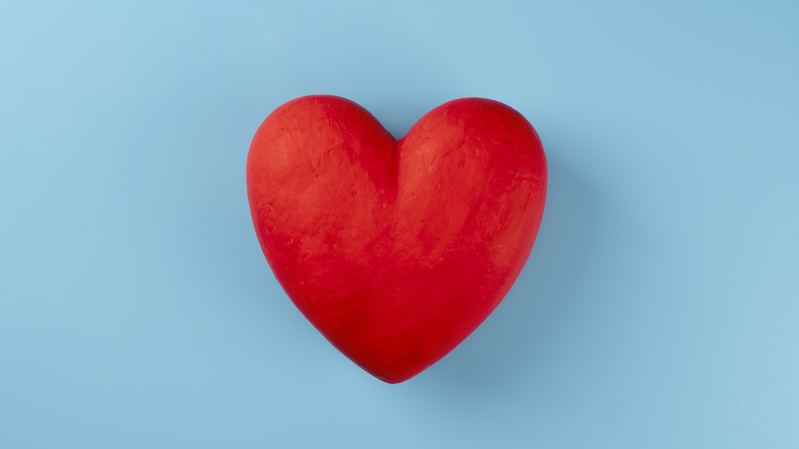 Большое красное сердце на голубом фоне