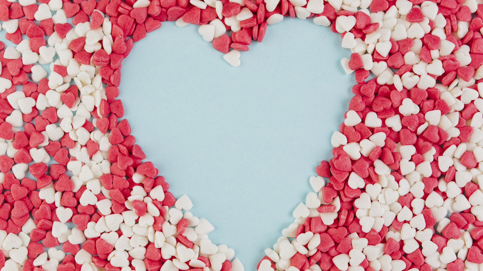 Сердце на голубом фоне из маленьких сладких сердечек