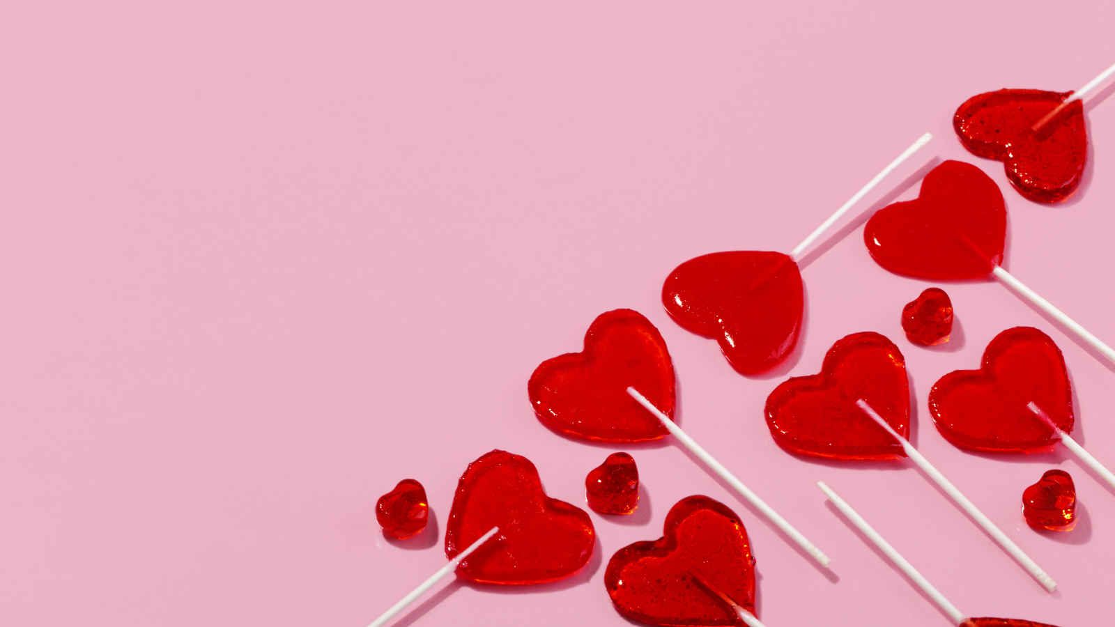 Леденцы в форме сердца на розовом фоне