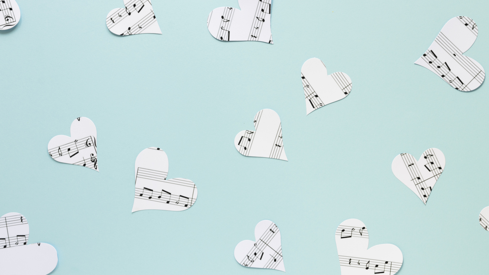 Сердечки из нотной тетради на голубом фоне
