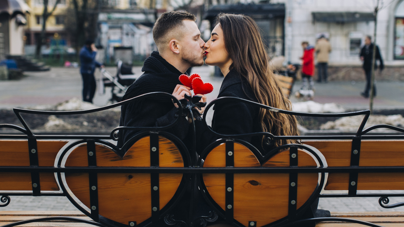 Поцелуй влюбленной пары на лавке в парке