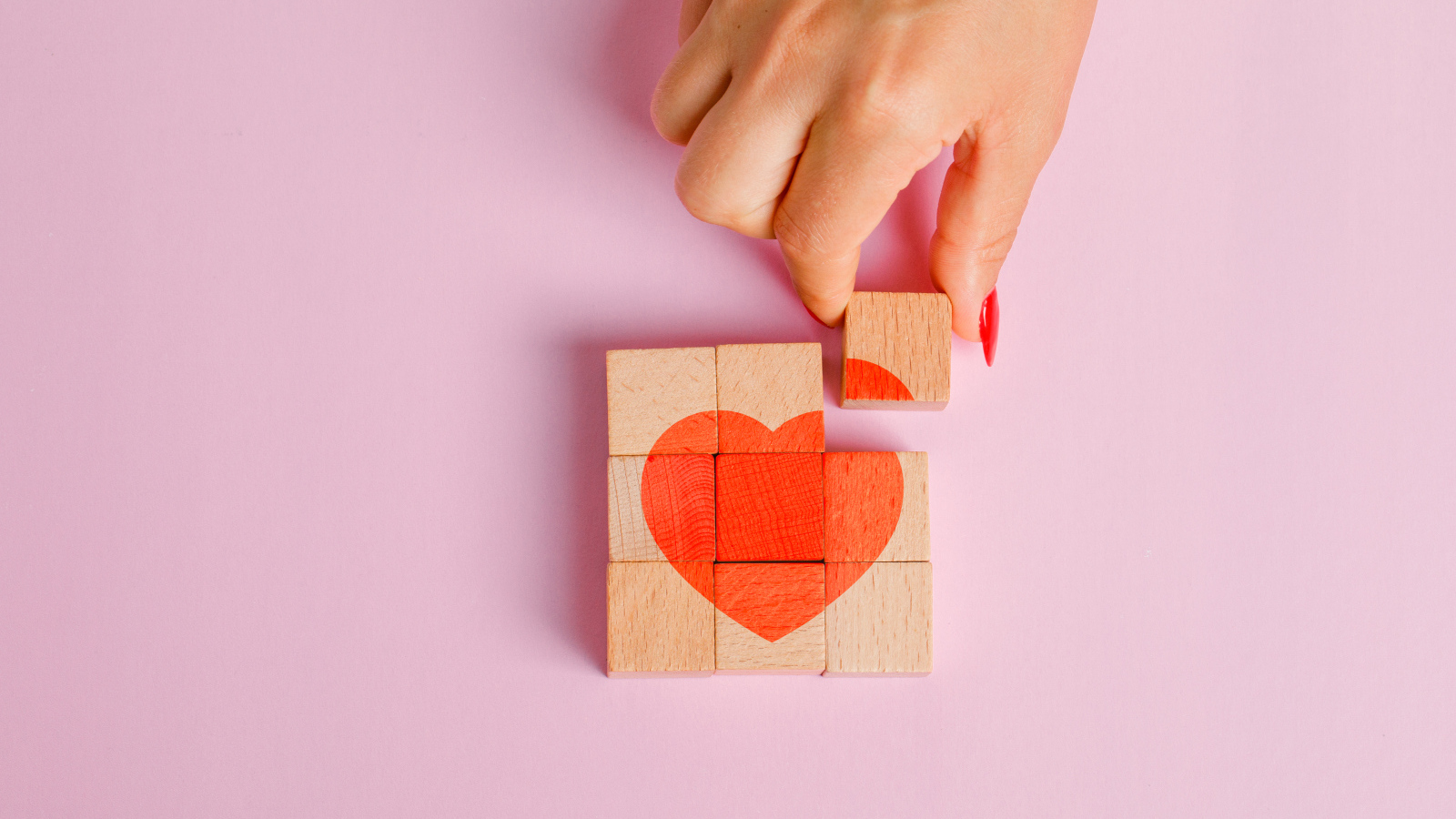Красное сердце из кубиков на розовом фоне