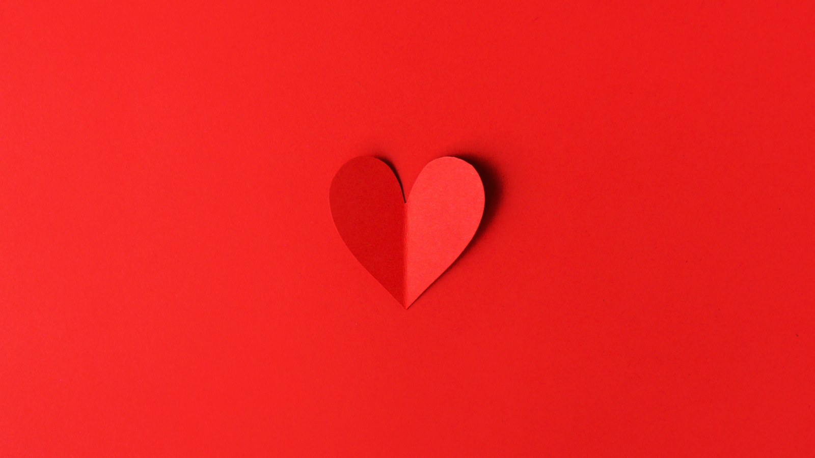 Маленькое бумажное сердце на красном фоне