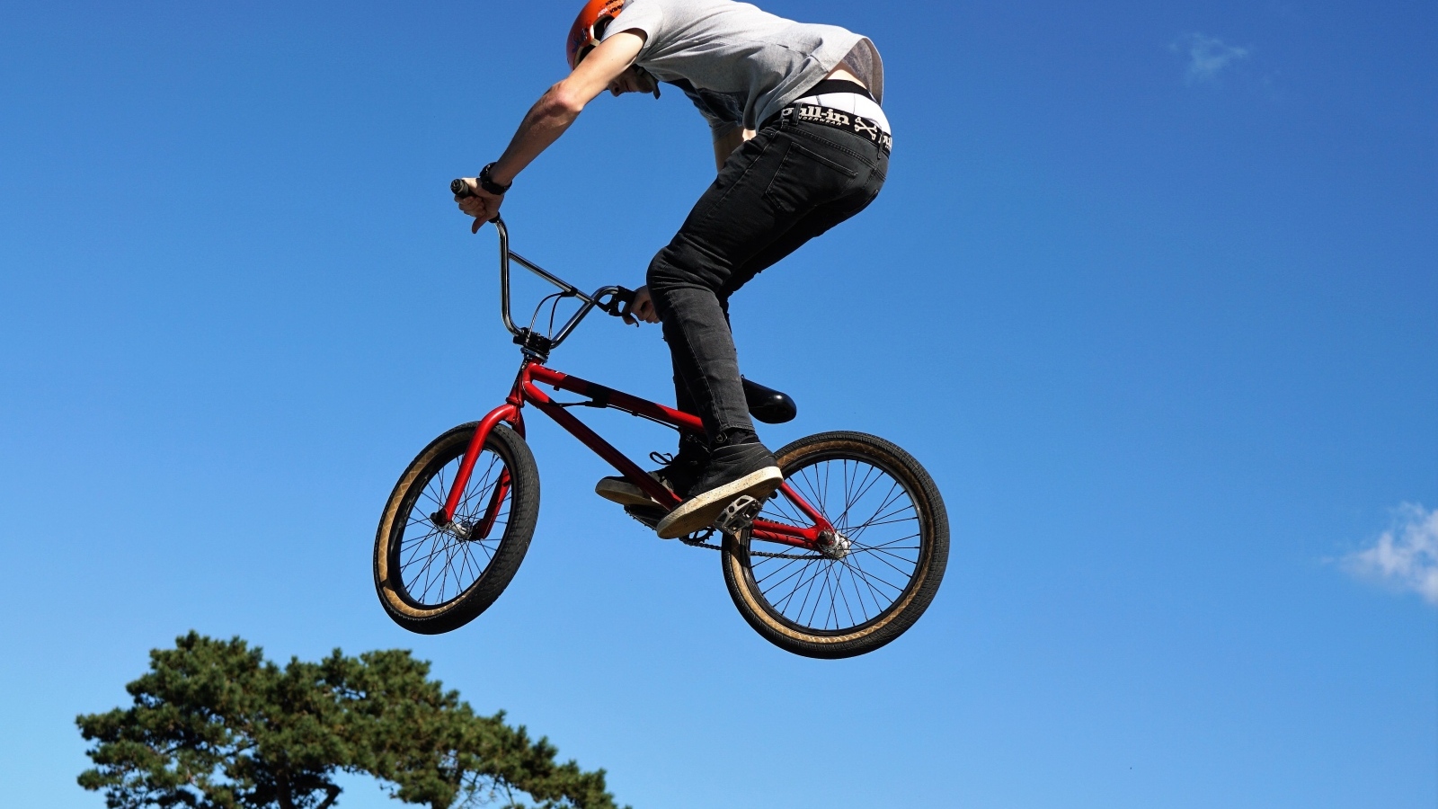 Мужчина делает прыжок на велосипеде на фоне неба