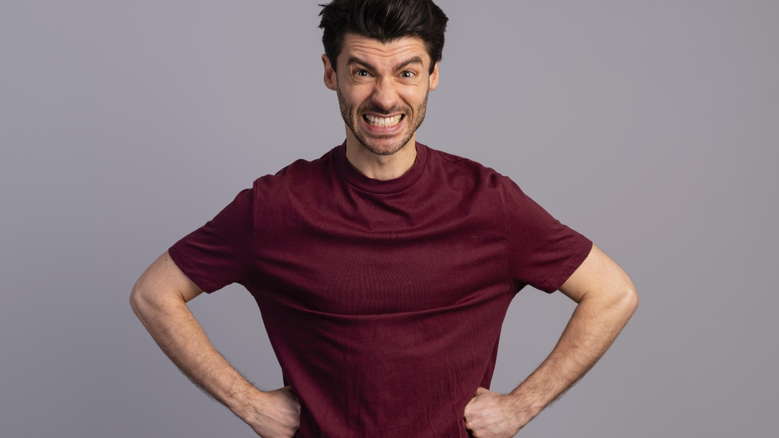 Злой мужчина на сером фоне