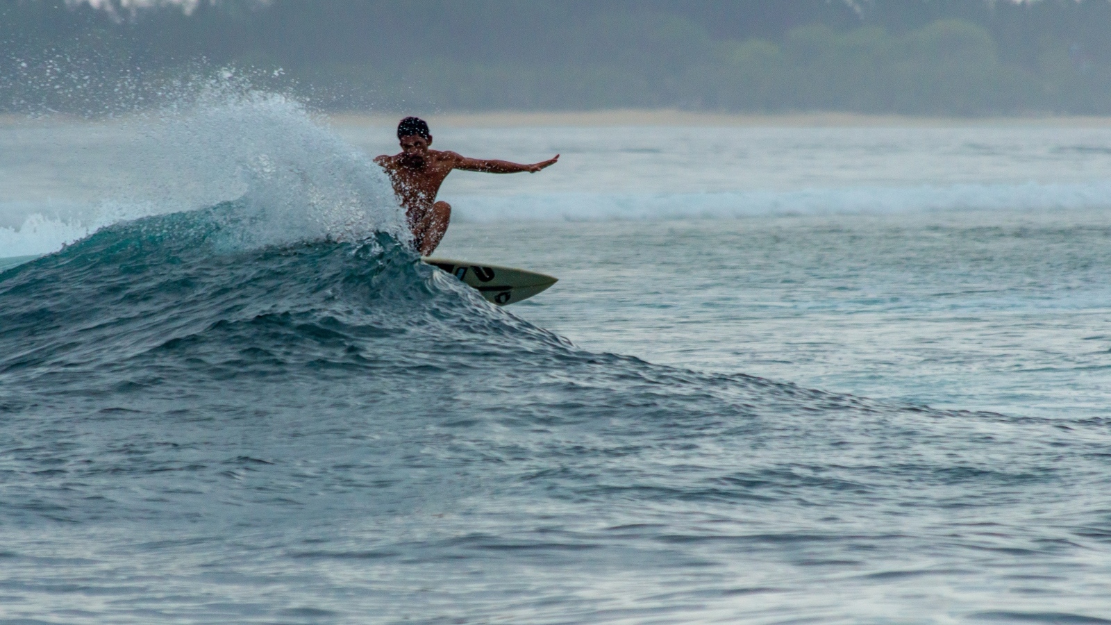 Мужчина серфингист ловит волну