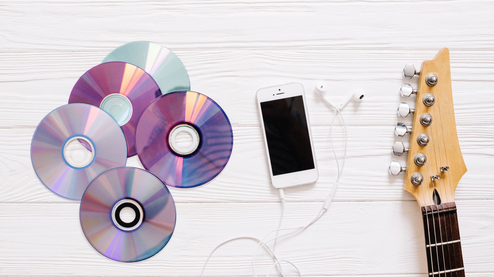 Диски с телефоном и гитарой на белом фоне