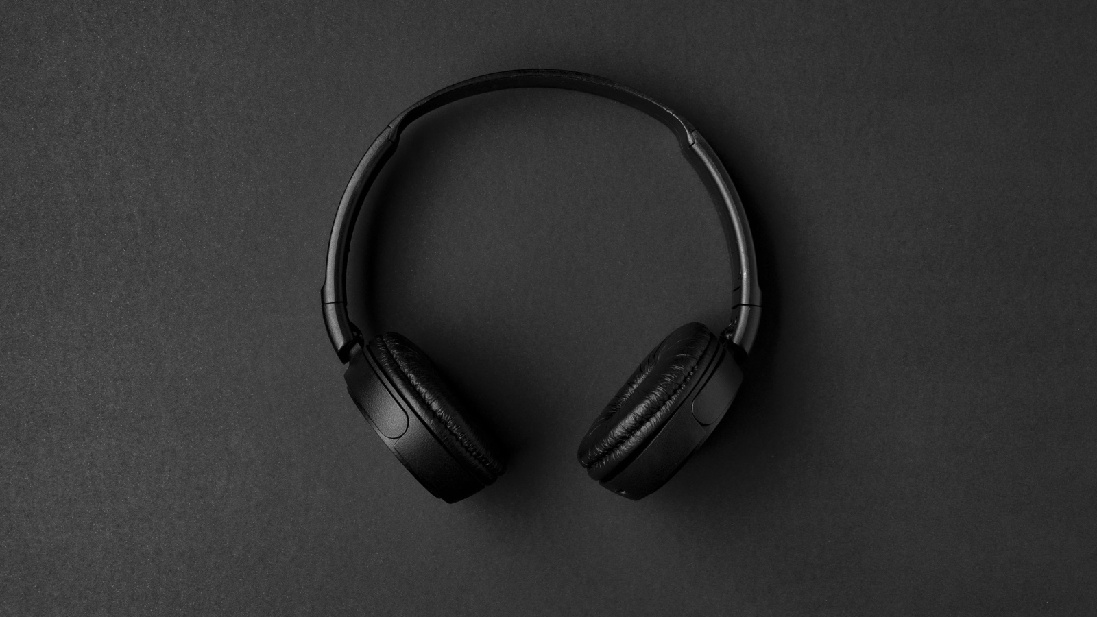 Большие черные наушники на сером столе