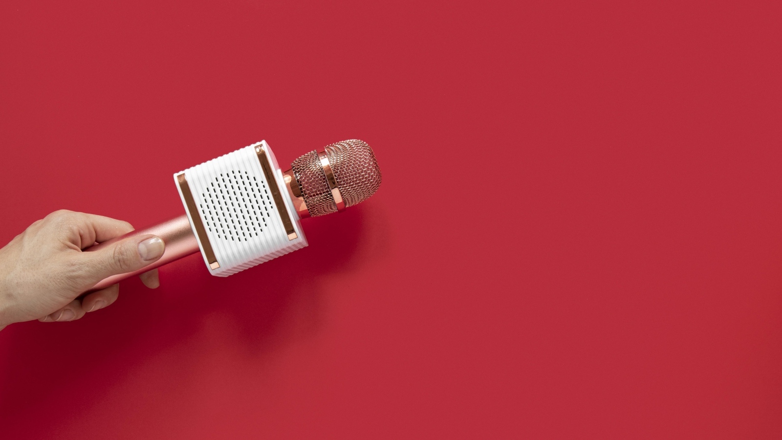 Радиомикрофон в руке на красном фоне