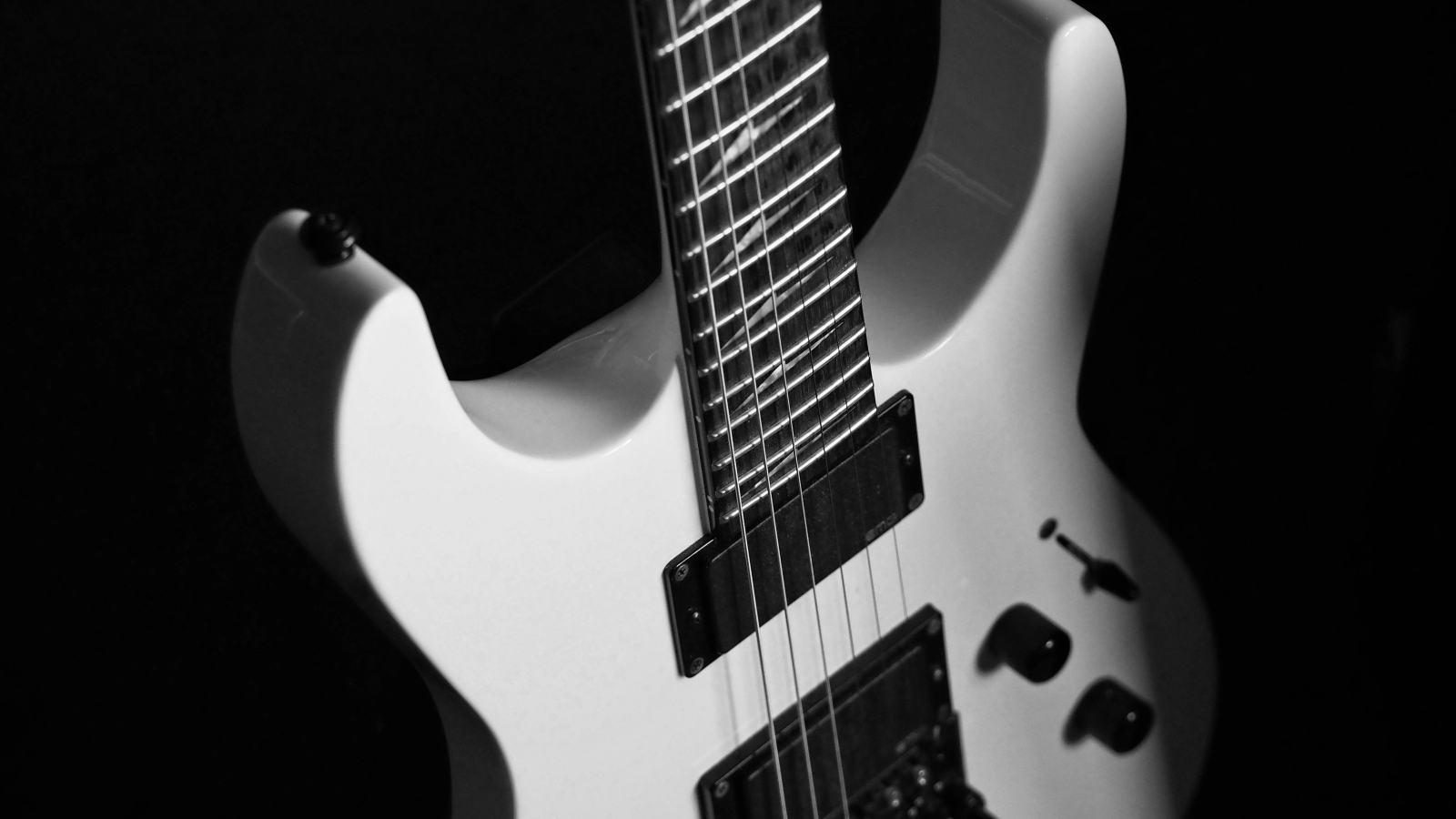 Белая электрогитара на черном фоне