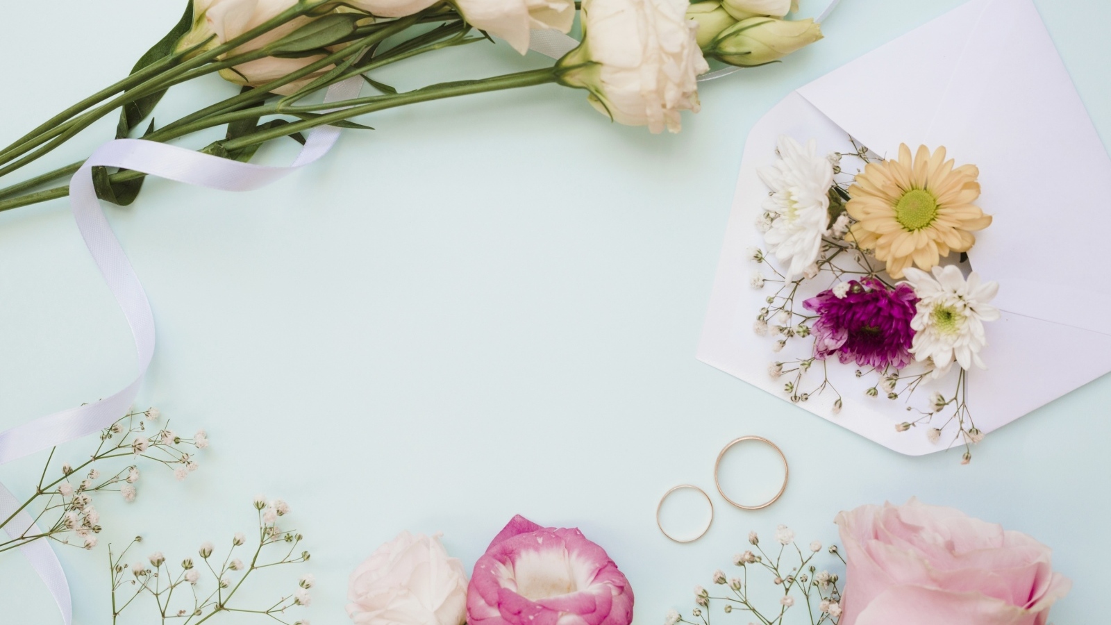 Цветы на голубом фоне с конвертом и обручальными кольцами