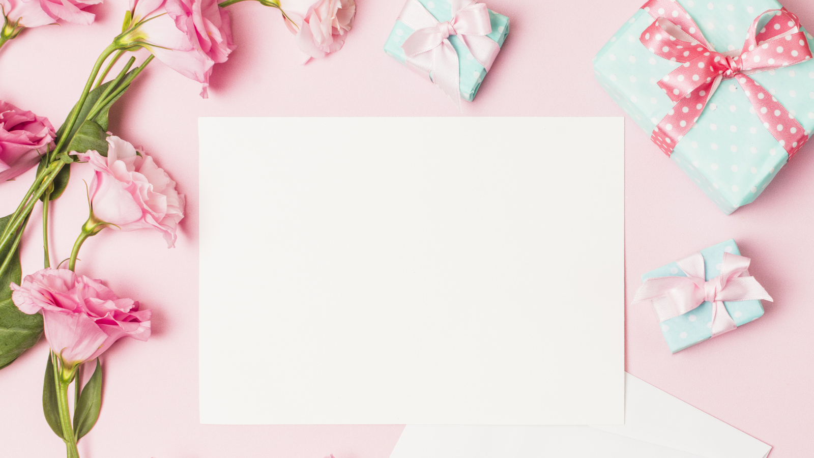 Розовые цветы эустомы с подарками и листом на розовом фоне