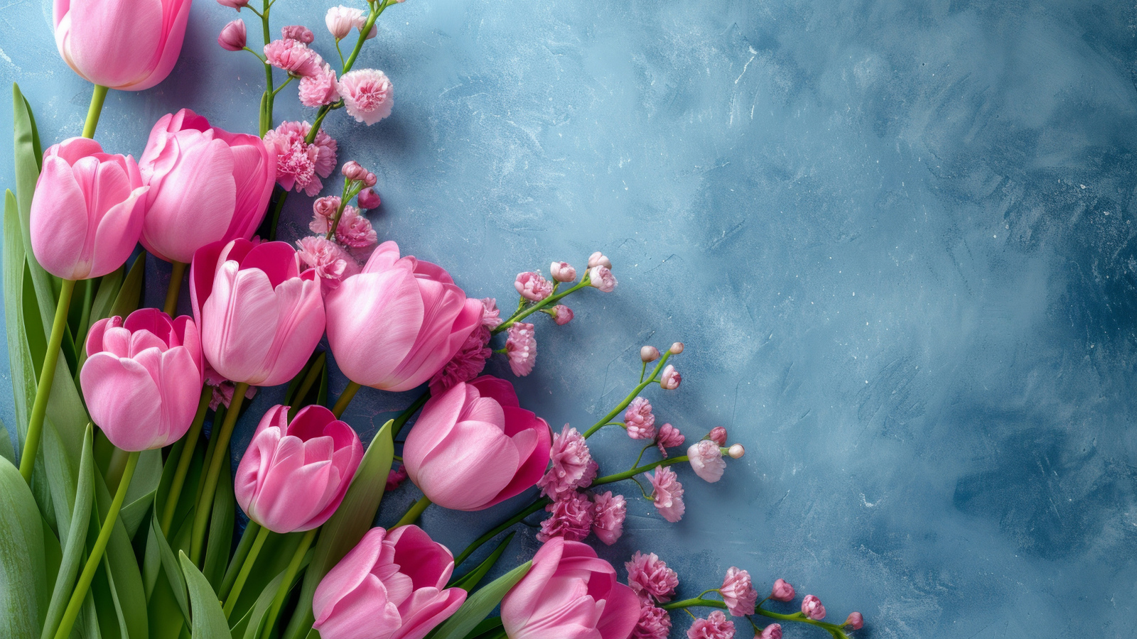 Розовые тюльпаны и гипсофила на сером столе