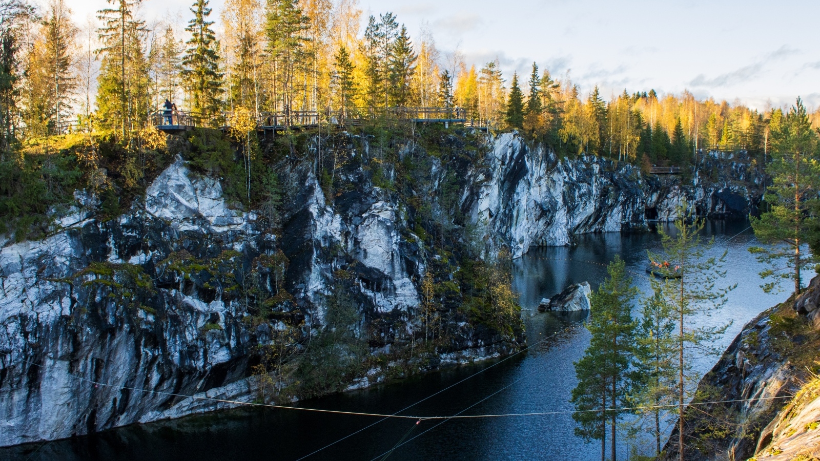 Вид на утес покрытый деревьями у воды
