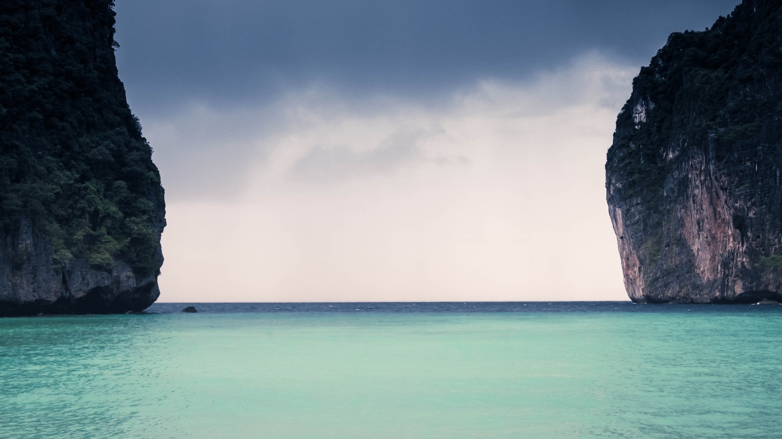 Голубая вода залива между скал