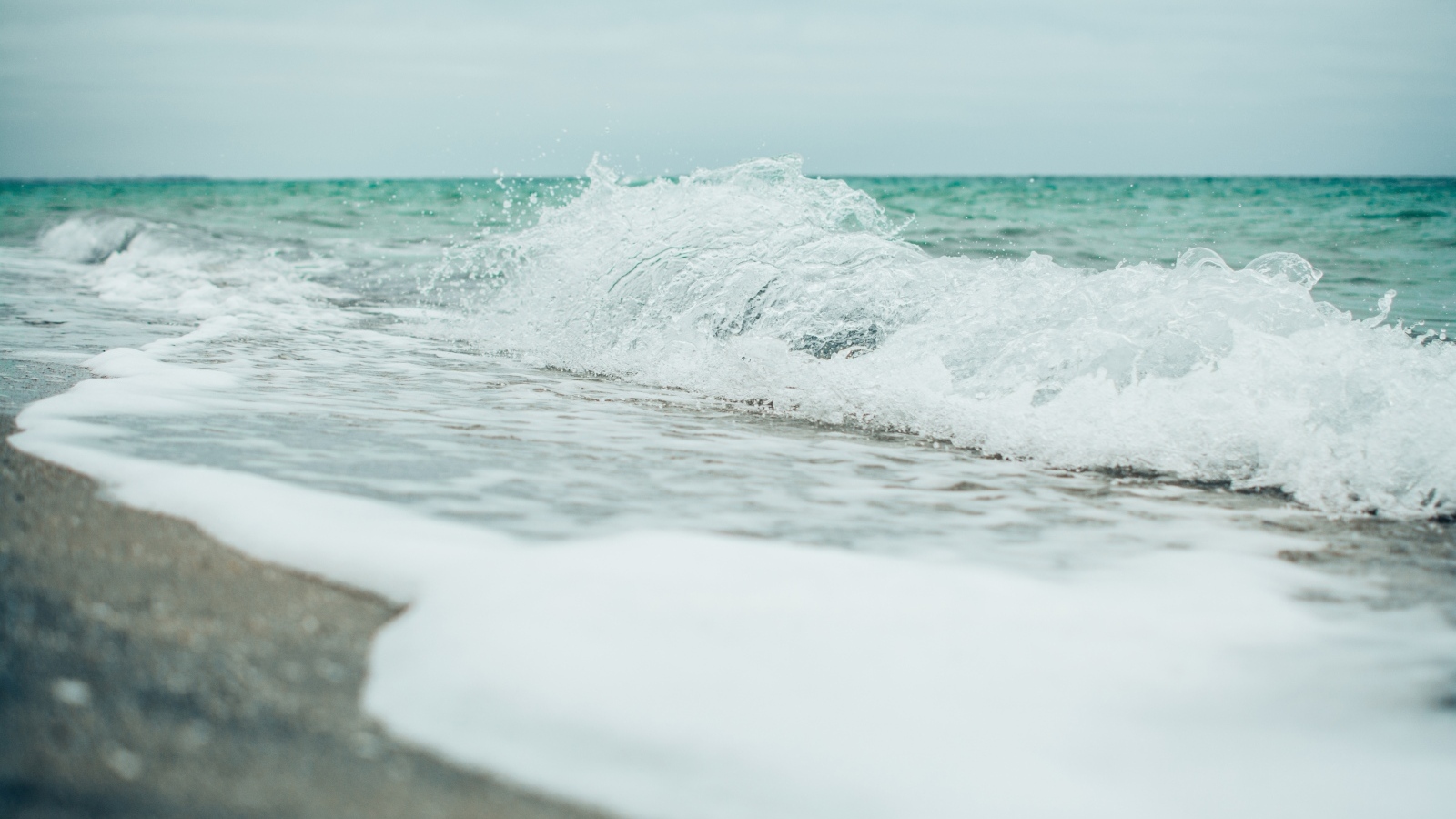 Белая морская пена на морском песке вблизи
