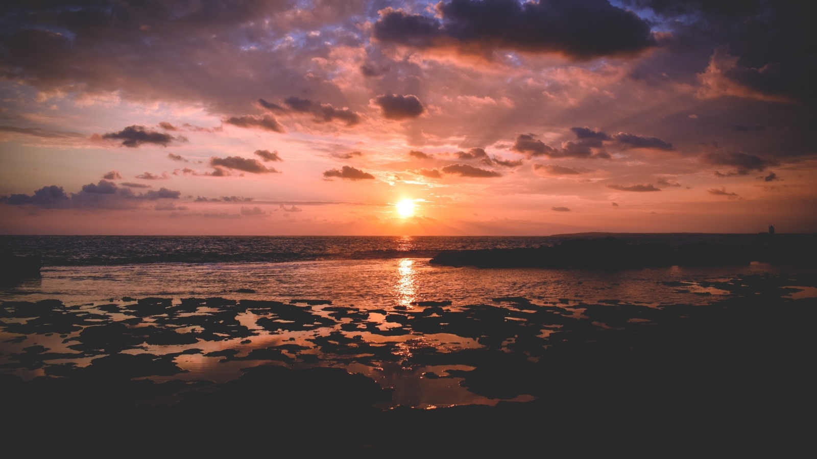 Закат яркого летнего солнца в небе над морем