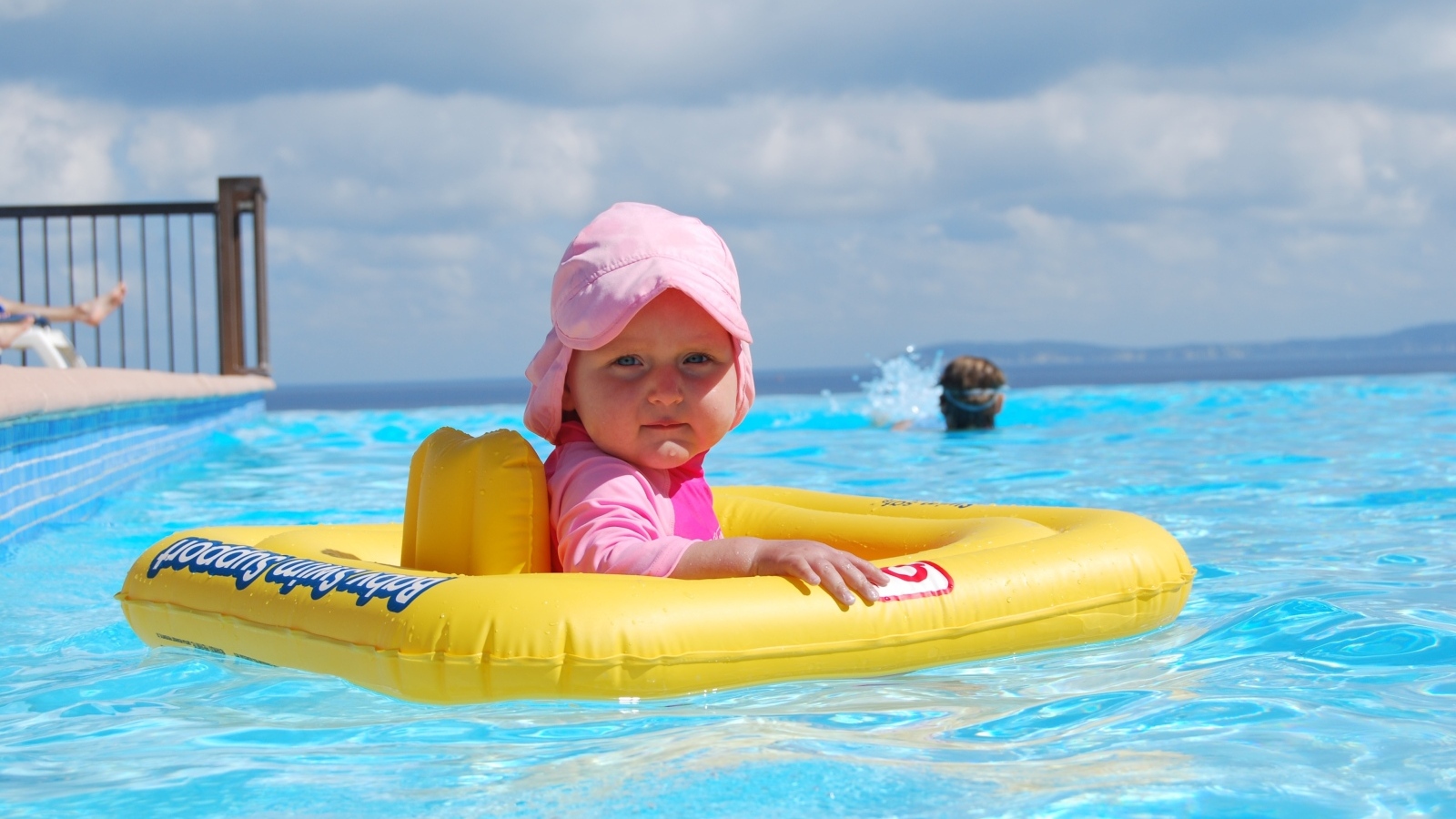 Ребенок со спасательным кругом плавает в бассейне