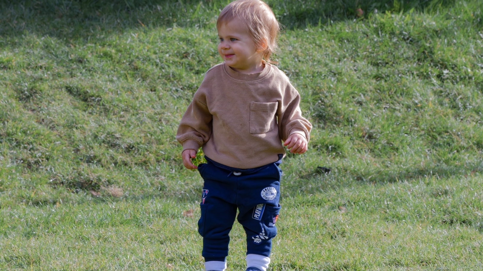 Веселый маленький мальчик гуляет на природе