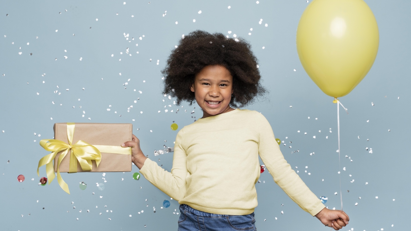 Счастливая девочка с подарком и шариком на голубом фоне