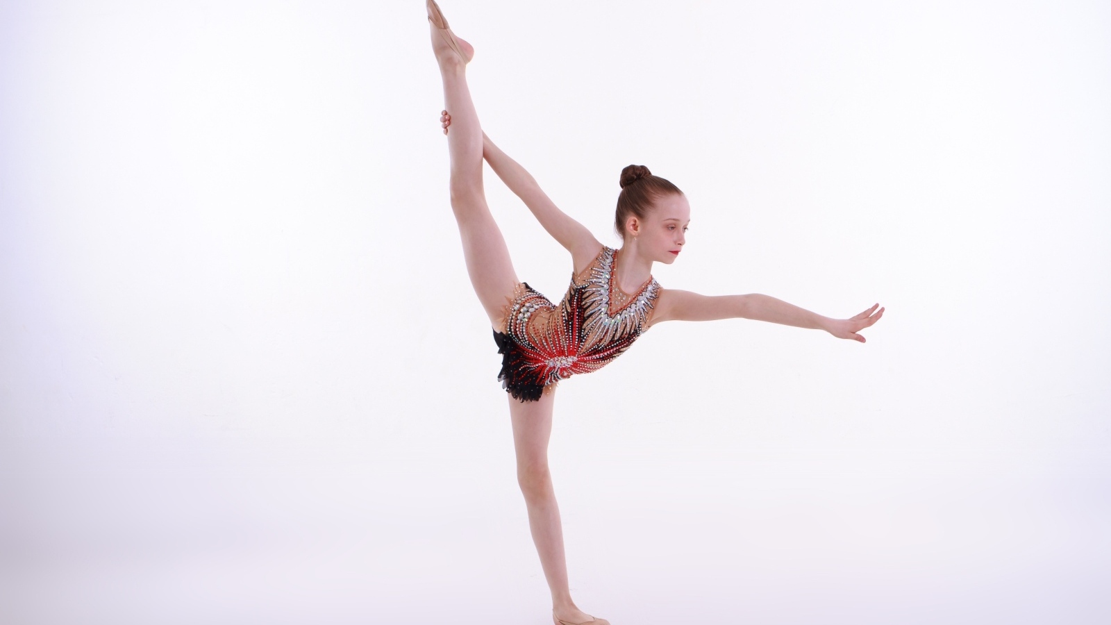 Маленькая девочка гимнастка на белом фоне