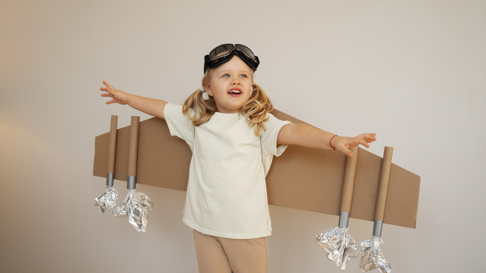 Маленькая девочка с крыльями из картона