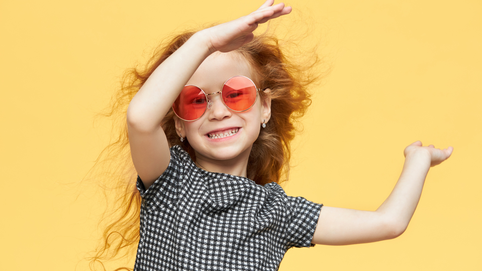 Улыбающаяся рыжеволосая девочка в очках