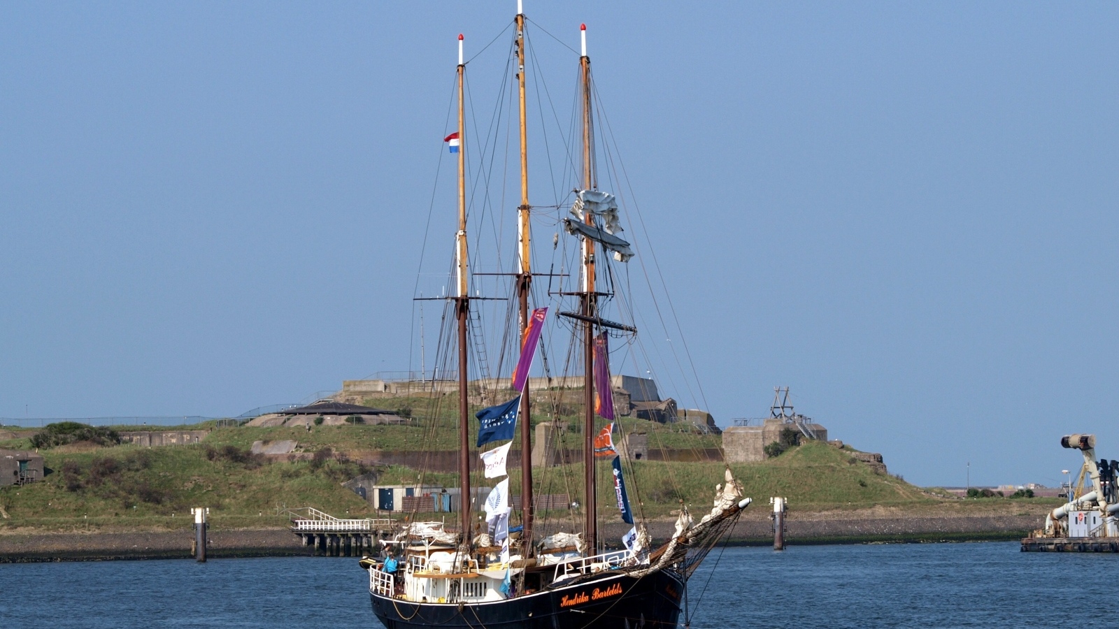 Большой корабль с опущенными парусами в гавани
