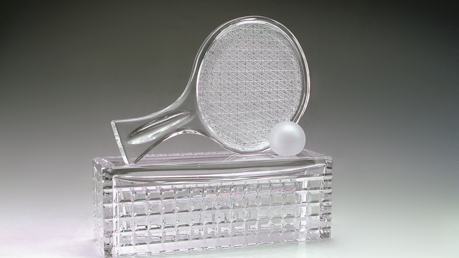 Хрустальная теннисная награда на сером фоне