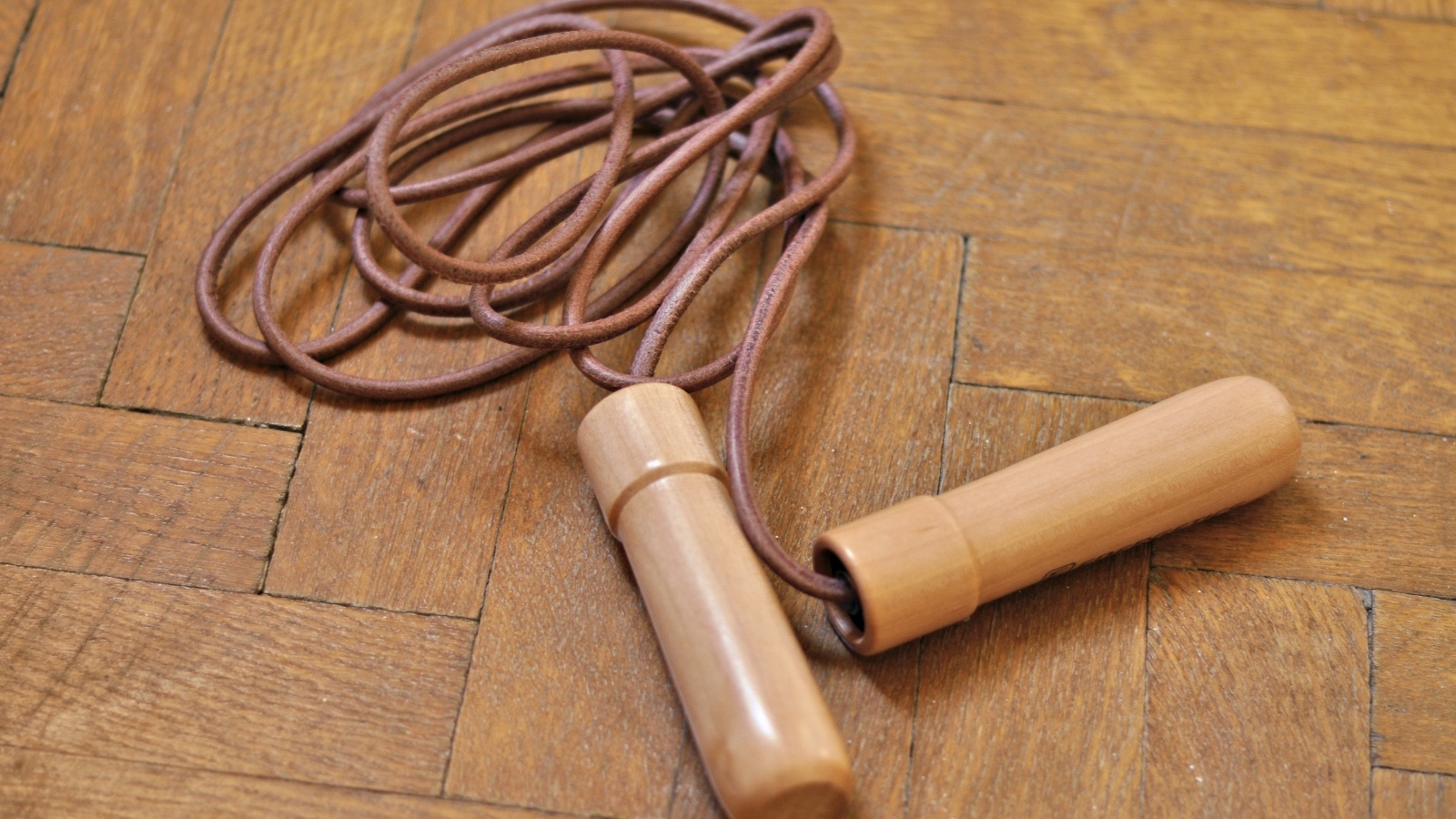 Скакалка лежит на деревянном полу