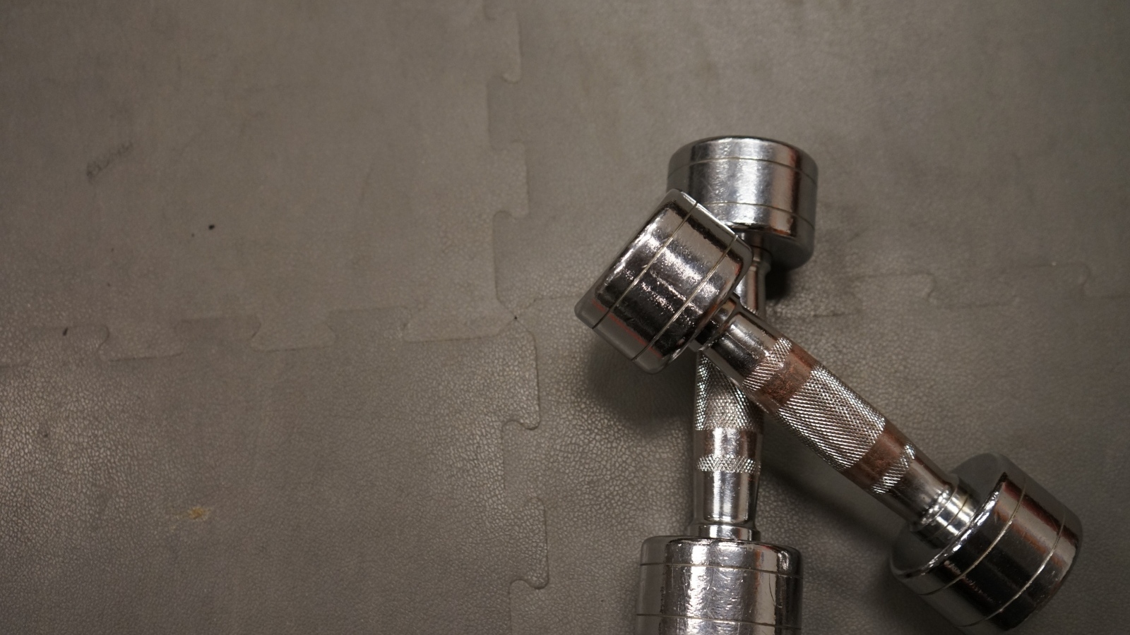 Две железные гантели на сером фоне