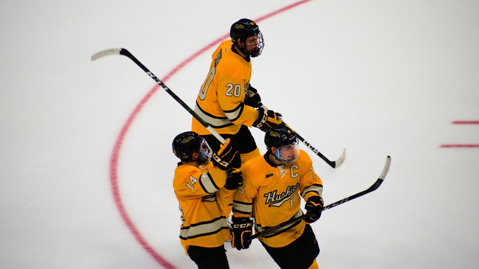 Три хоккеиста с клюшками на льду