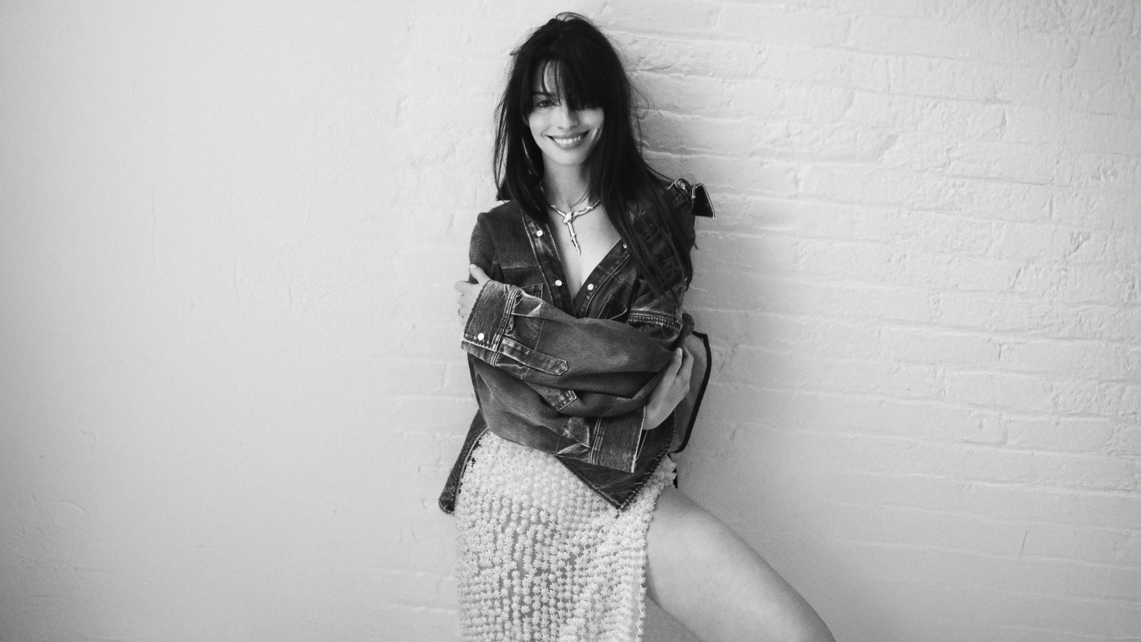 Актриса Энн Хэтэуэй стоит у стены черно-белое фото