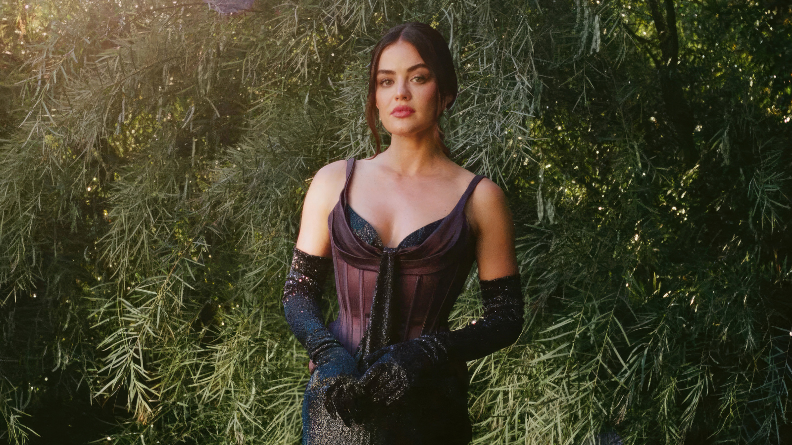 Актриса Люси Хейл в черном платье у зеленых зарослей