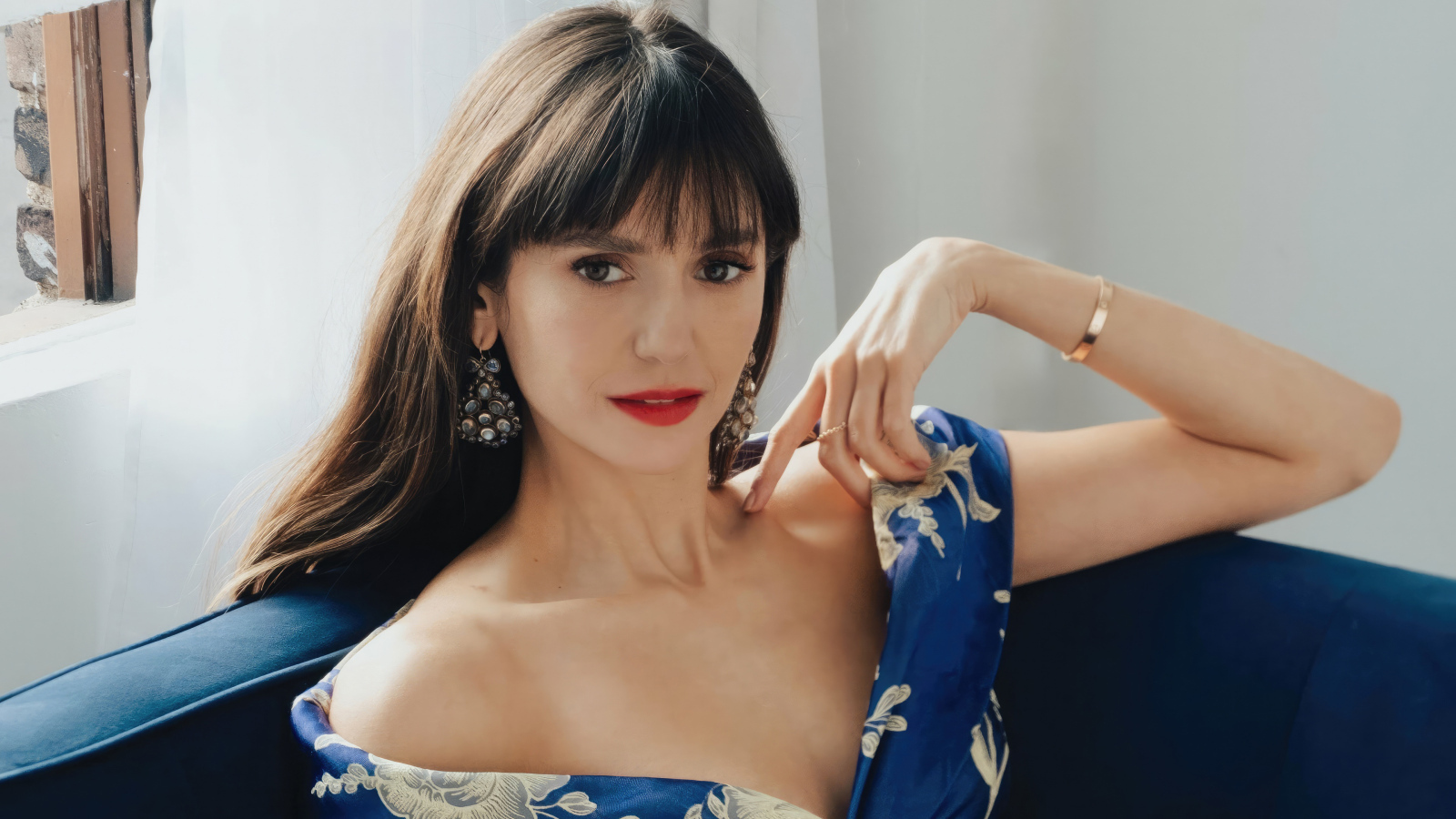 Милая девушка актриса Нина Добрев на диване