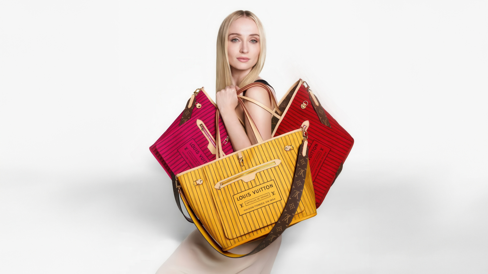 Софи Тернер с сумками Луи Виттон на белом фоне