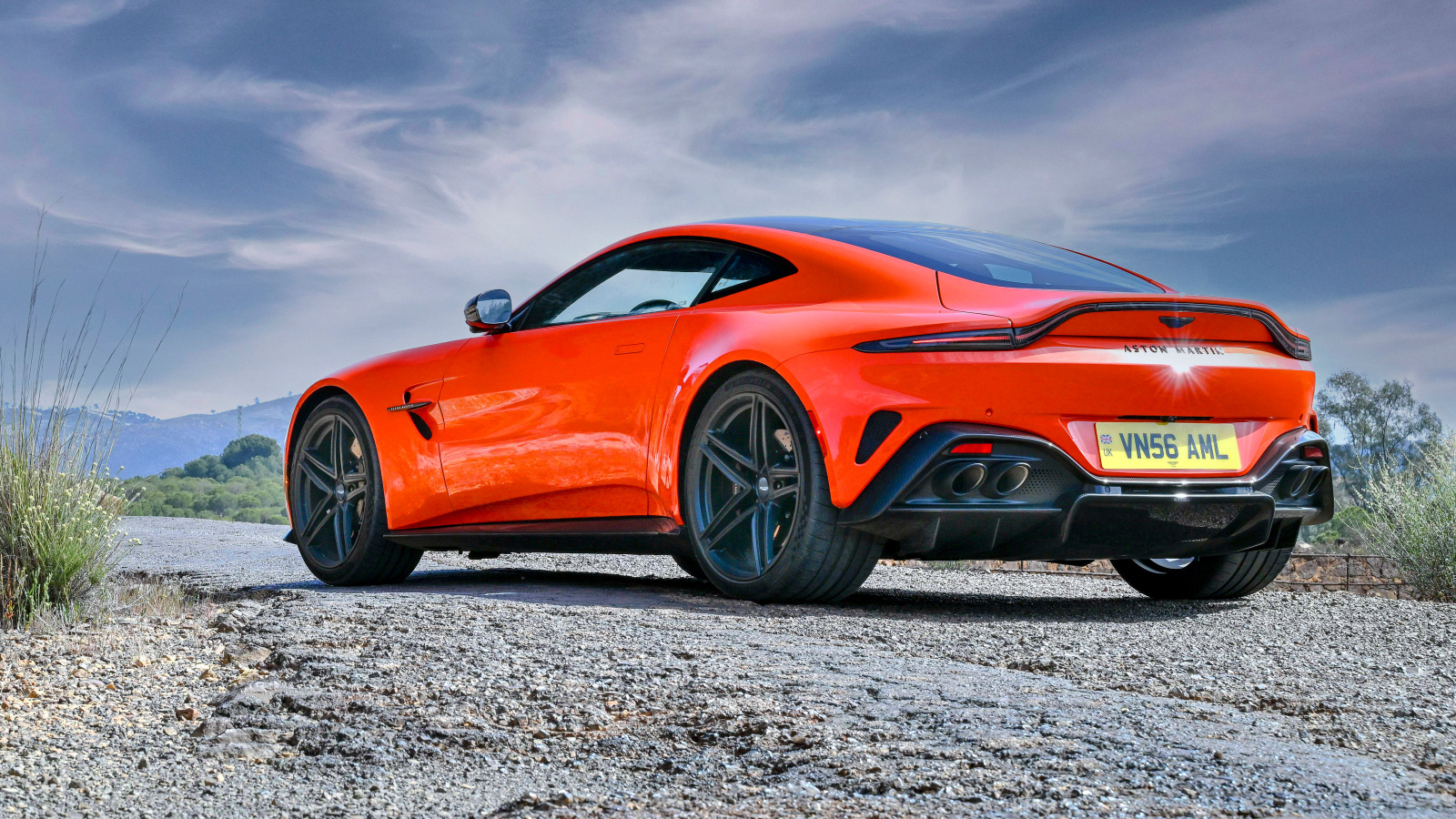 Вид сзади на красный автомобиль Aston Martin Vantage 2025 года