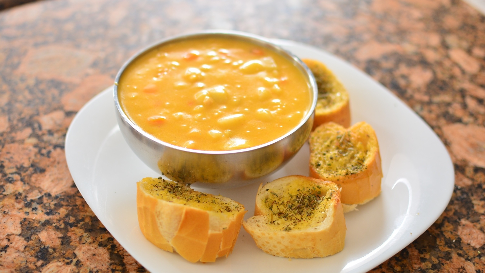 Суп с фасолью на тарелке с гренками