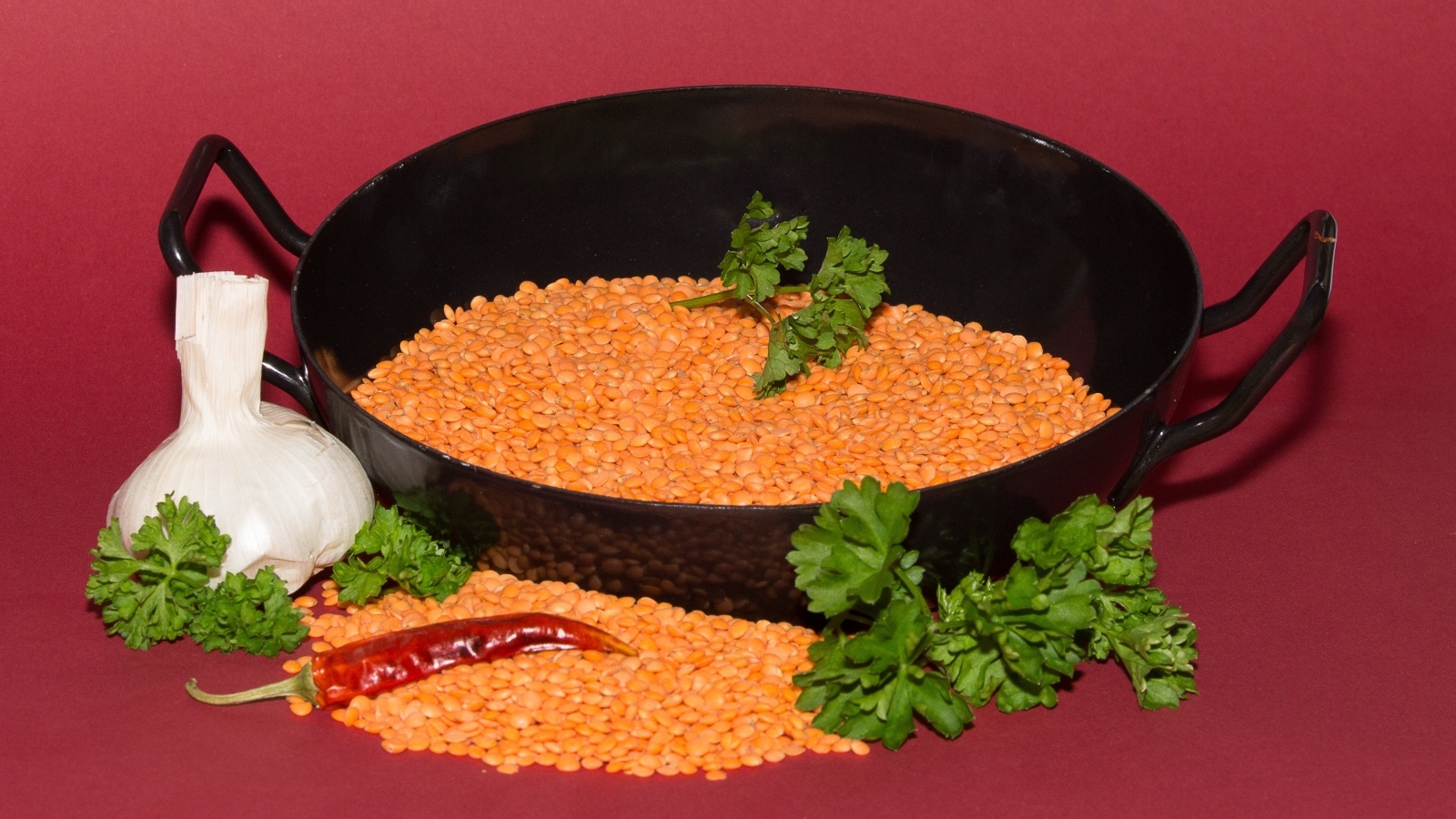 Бобы с чесноком и петрушкой на красном фоне