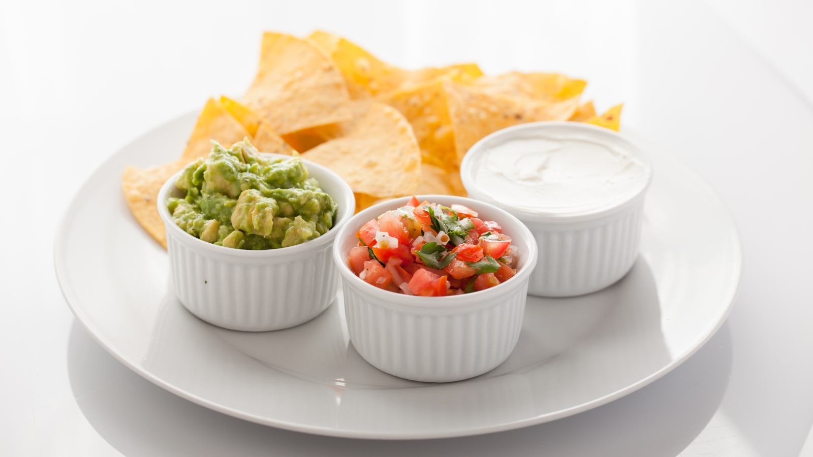 Чипсы с соусом на большой белой тарелке