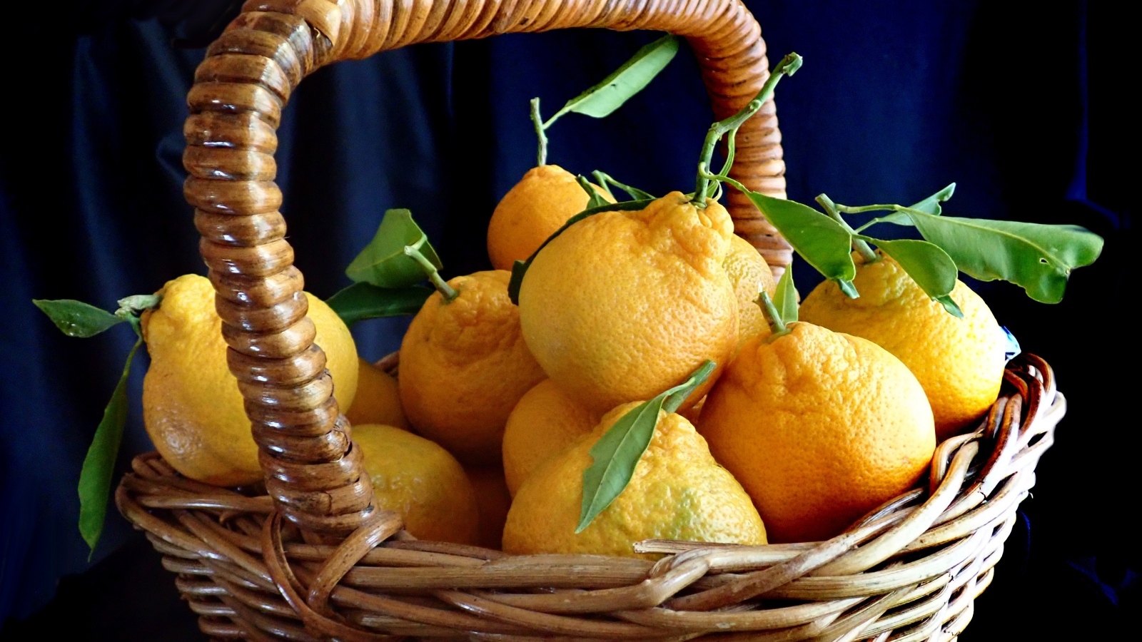 Корзина крупных желтых лимонов на столе
