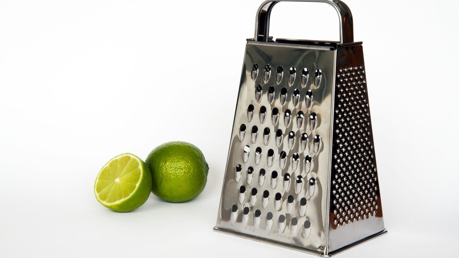 Терка с зеленым лаймом на сером фоне