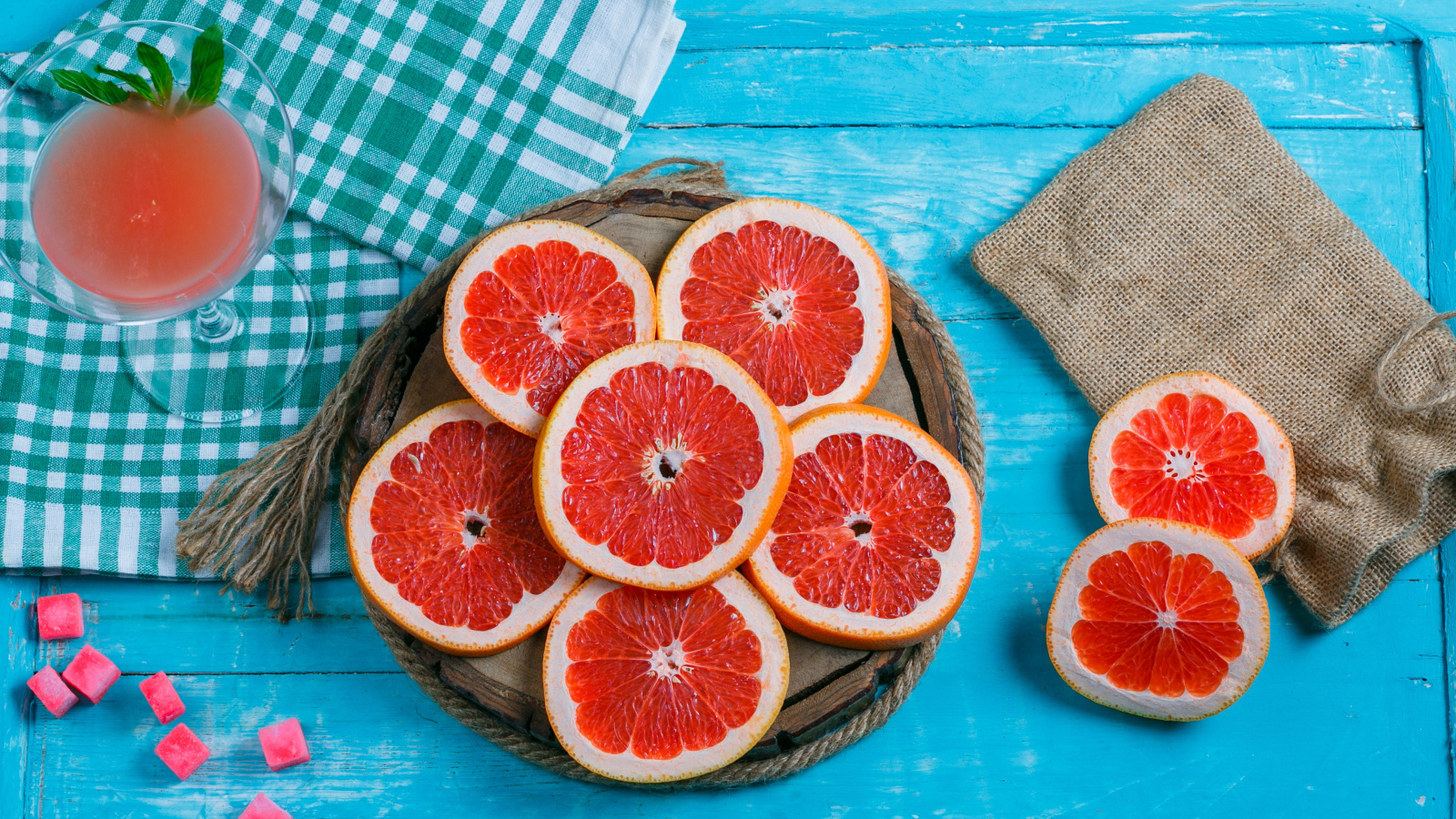 Нарезанный грейпфрут с соком на голубом столе